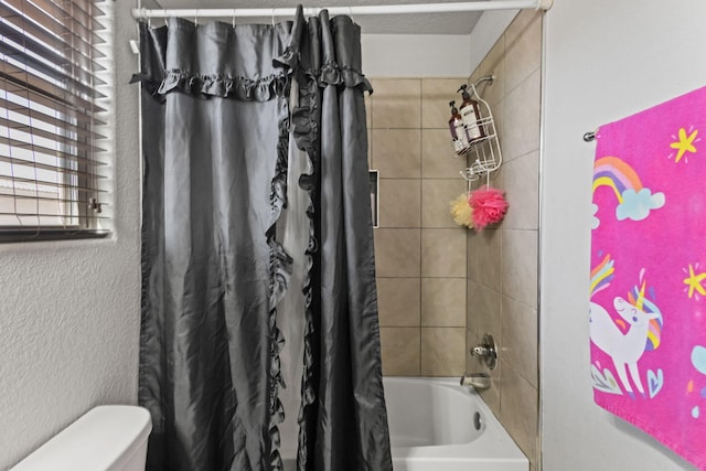 bathroom featuring shower / bath combo and toilet