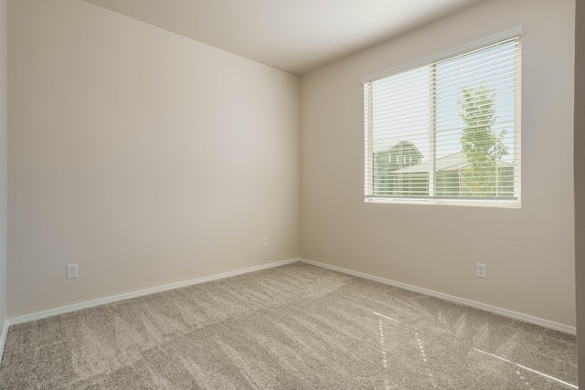 unfurnished room with carpet and baseboards