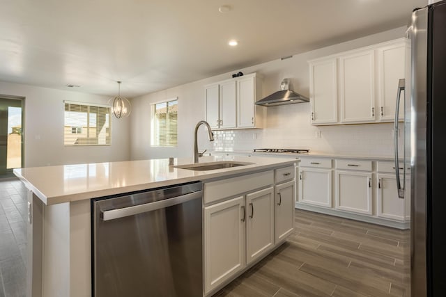 kitchen featuring stainless steel appliances, backsplash, a sink, and white cabinetry