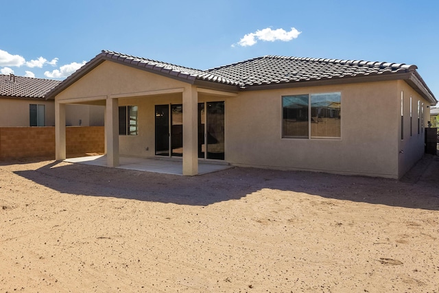 back of property with a patio area, fence, a tiled roof, and stucco siding