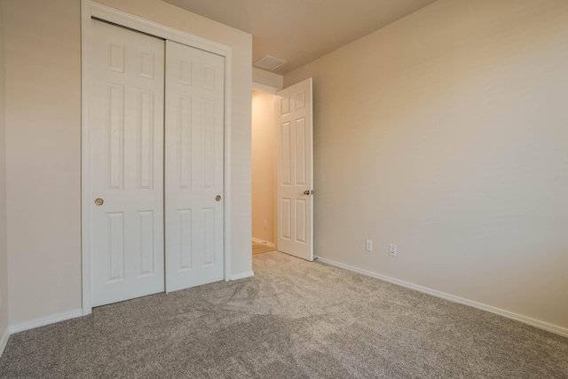 unfurnished bedroom with a closet, carpet, visible vents, and baseboards