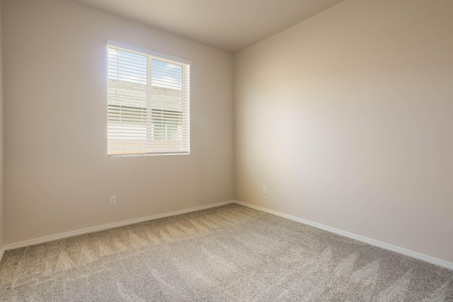 empty room featuring carpet and baseboards