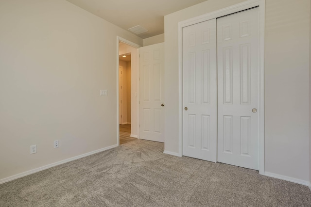 unfurnished bedroom with carpet, baseboards, and a closet