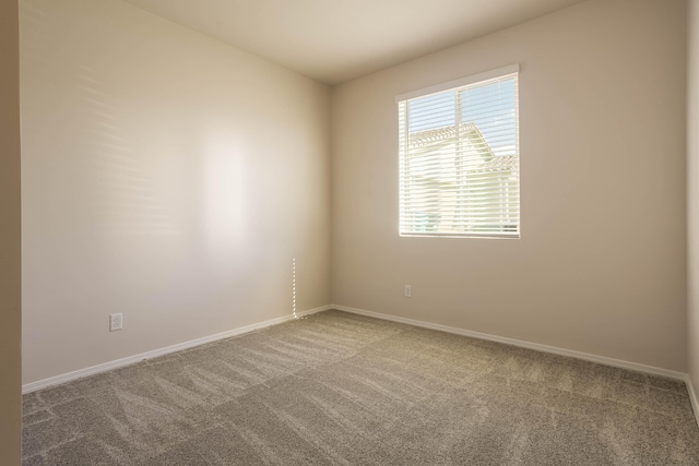 unfurnished room featuring carpet and baseboards