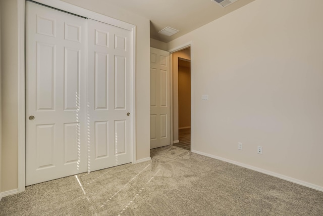 unfurnished bedroom featuring carpet, a closet, visible vents, and baseboards