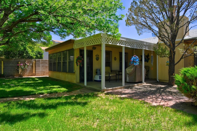 rear view of property featuring a yard and a patio