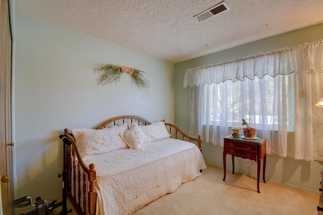 carpeted bedroom featuring a textured ceiling