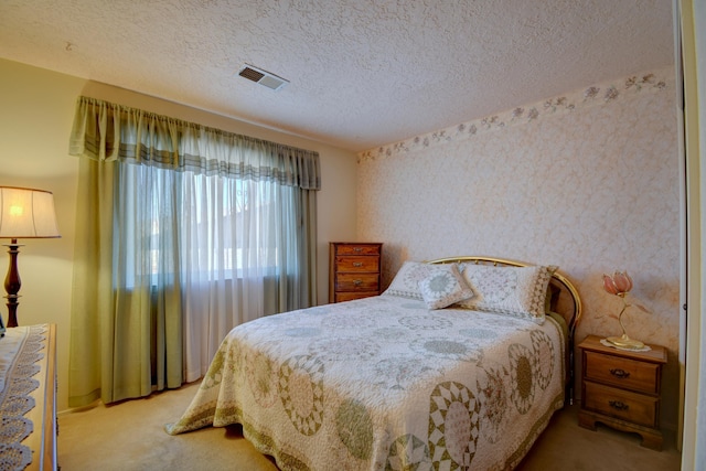 bedroom with light carpet and a textured ceiling