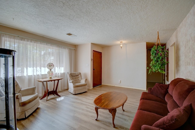 living room featuring a textured ceiling and light wood-type flooring