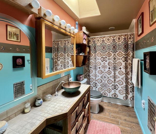 bathroom with hardwood / wood-style floors, vanity, and toilet