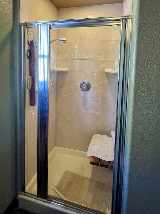 bathroom with a shower with door