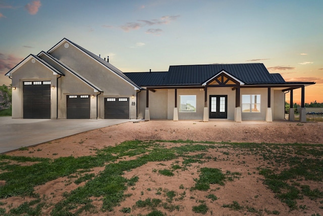 modern inspired farmhouse featuring french doors and a garage