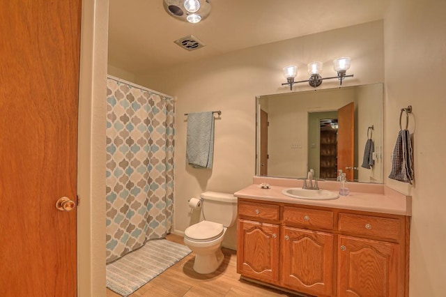 bathroom with wood-type flooring, vanity, and toilet