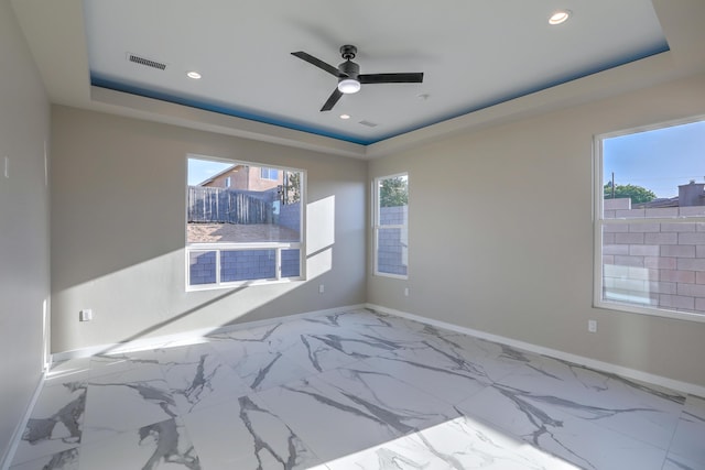 unfurnished room with a tray ceiling and ceiling fan