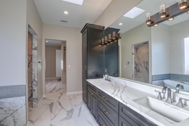 bathroom featuring vanity, a tub, and a skylight