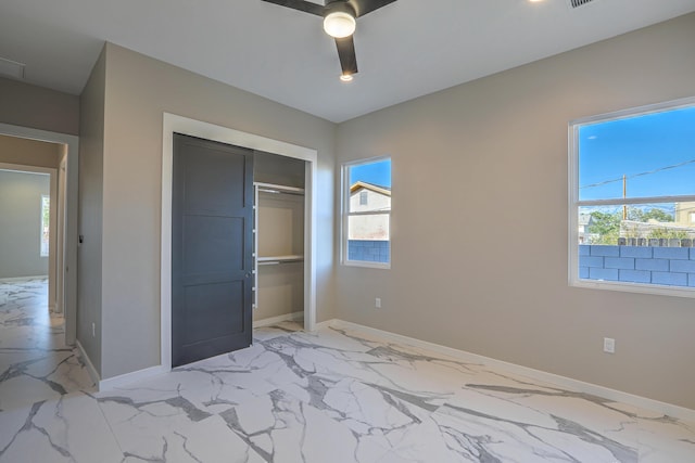 unfurnished bedroom featuring ceiling fan and a closet