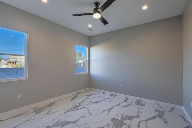 spare room featuring ceiling fan and a healthy amount of sunlight