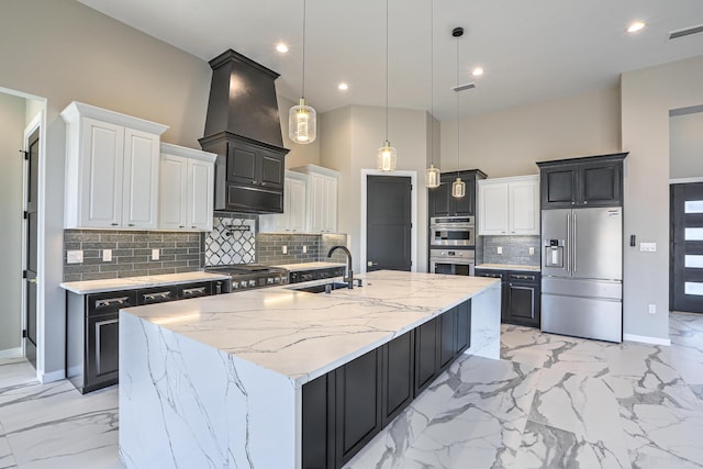 kitchen with white cabinets, sink, hanging light fixtures, appliances with stainless steel finishes, and a large island