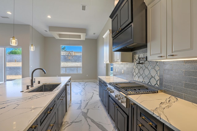 kitchen with backsplash, light stone counters, stainless steel appliances, sink, and decorative light fixtures