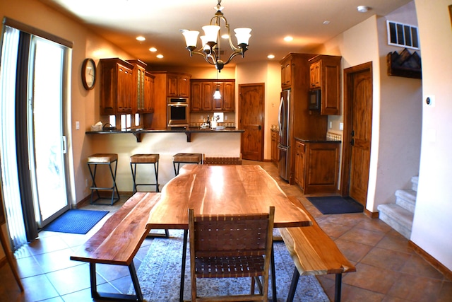 dining room with tile patterned flooring, a notable chandelier, and a wealth of natural light