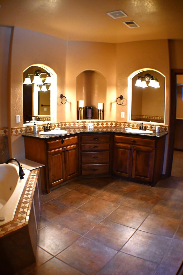 bathroom with tile patterned floors, vanity, and a relaxing tiled tub