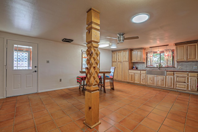 kitchen featuring pendant lighting, ceiling fan, sink, tasteful backsplash, and light tile patterned floors