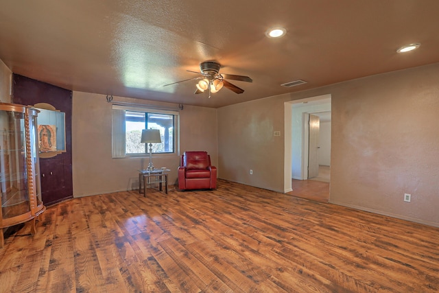 unfurnished room featuring ceiling fan, hardwood / wood-style floors, and a textured ceiling