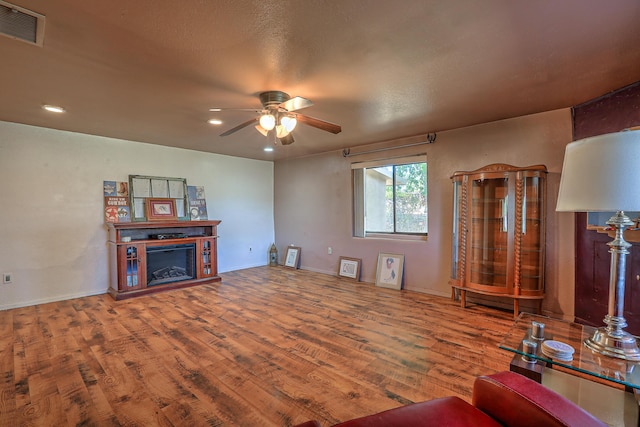 living room with wood-type flooring and ceiling fan