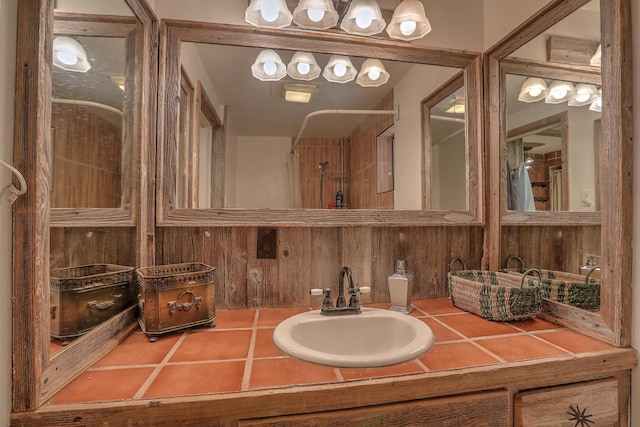 bathroom with vanity, wood walls, and a shower