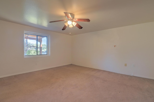 spare room with ceiling fan and carpet