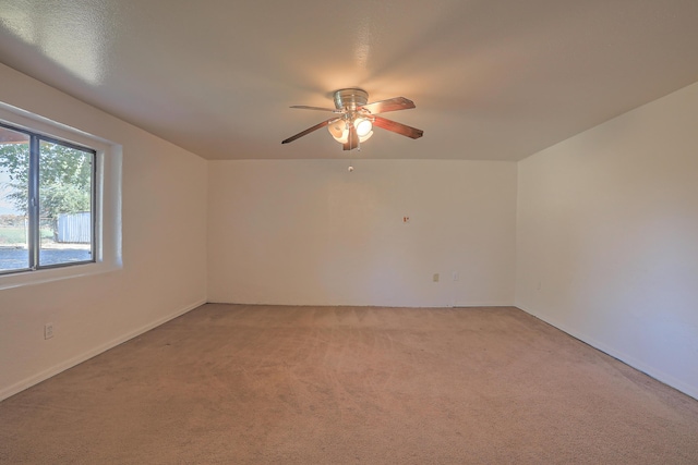 carpeted spare room featuring ceiling fan