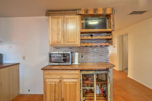 bar with light brown cabinetry and light tile patterned floors