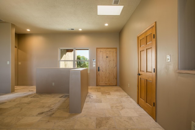 entryway featuring a textured ceiling and a skylight