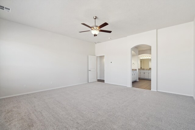 spare room with ceiling fan and light carpet