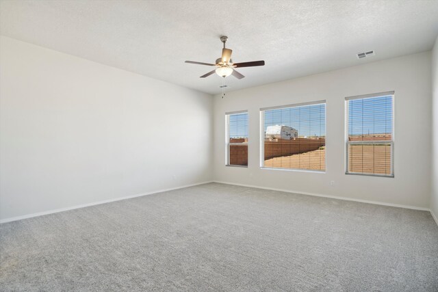 empty room with a textured ceiling, carpet floors, and ceiling fan