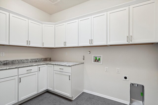 washroom with electric dryer hookup, cabinets, hookup for a gas dryer, washer hookup, and dark tile patterned floors