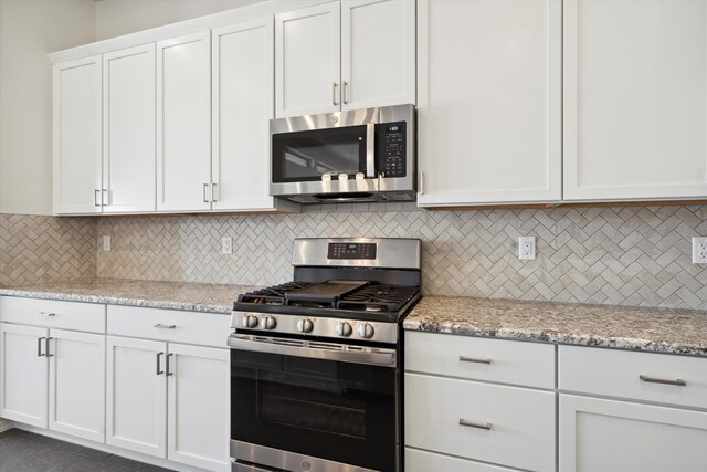 kitchen featuring light stone counters, white cabinetry, stainless steel appliances, and tasteful backsplash