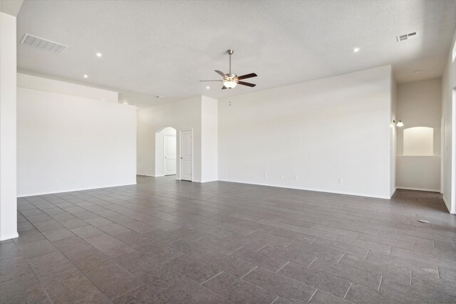 unfurnished room with ceiling fan and a textured ceiling