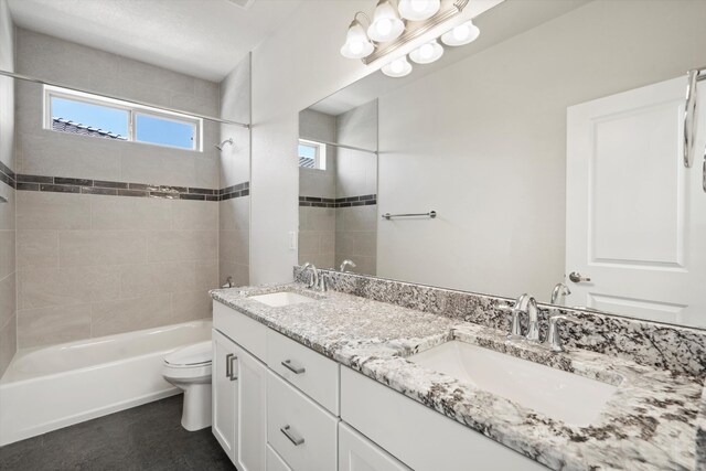 full bathroom with vanity, tiled shower / bath combo, and toilet