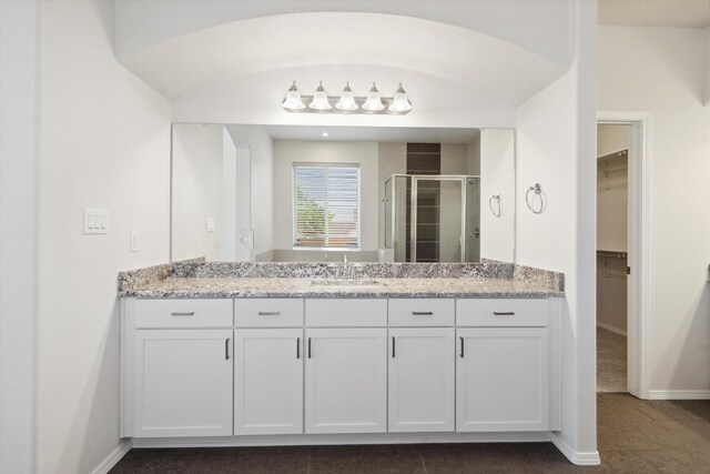 bathroom with tile patterned flooring, vanity, and walk in shower