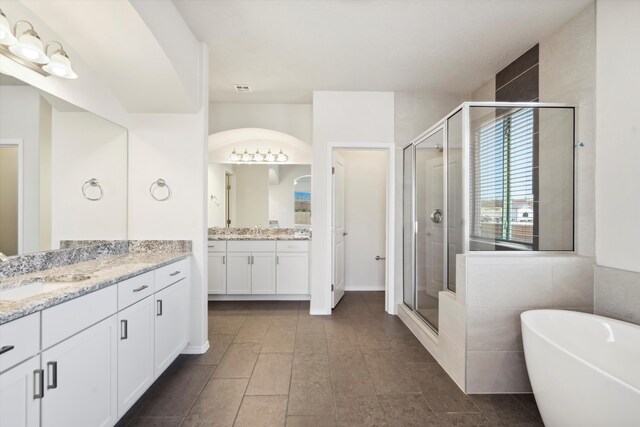 bathroom featuring vanity and independent shower and bath