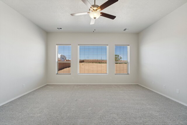 carpeted spare room with a textured ceiling and ceiling fan