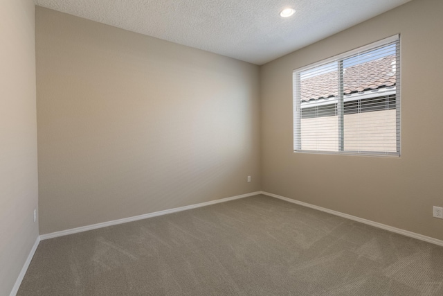 carpeted spare room featuring a textured ceiling