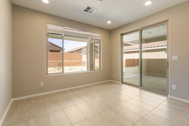 tiled spare room with a textured ceiling