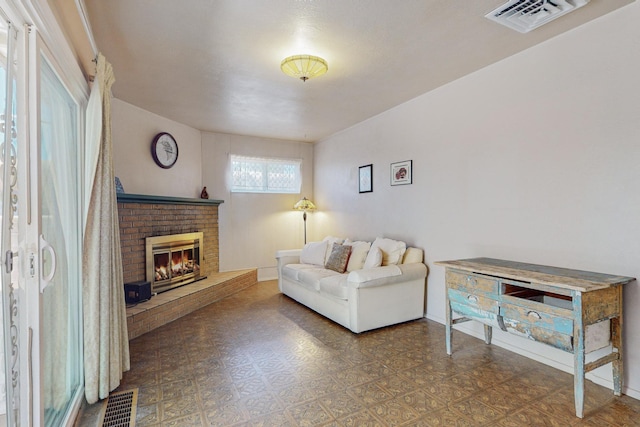 living area featuring visible vents, a fireplace, baseboards, and tile patterned floors