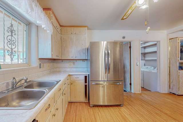 kitchen featuring ceiling fan, light hardwood / wood-style floors, pendant lighting, sink, and stainless steel refrigerator