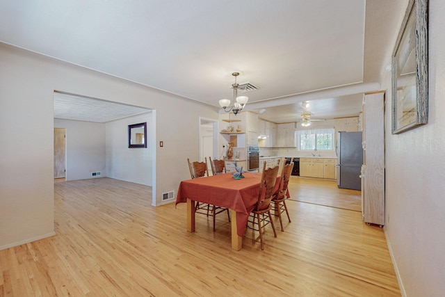 dining room with a chandelier, visible vents, and light wood-style floors