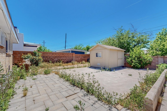 view of patio / terrace featuring a storage shed, an outdoor structure, and a fenced backyard