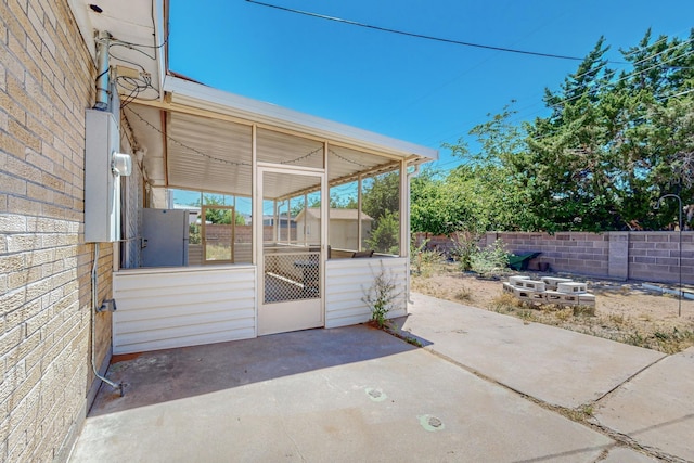 view of patio with a fenced backyard and a sunroom