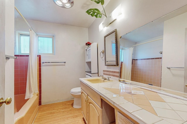 bathroom featuring toilet, vanity, shower / bath combination with curtain, and wood finished floors